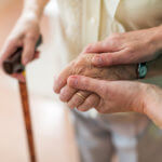 Elderly woman being helped by nursing home nurse.