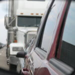 View of a truck in a car's rearview mirror.