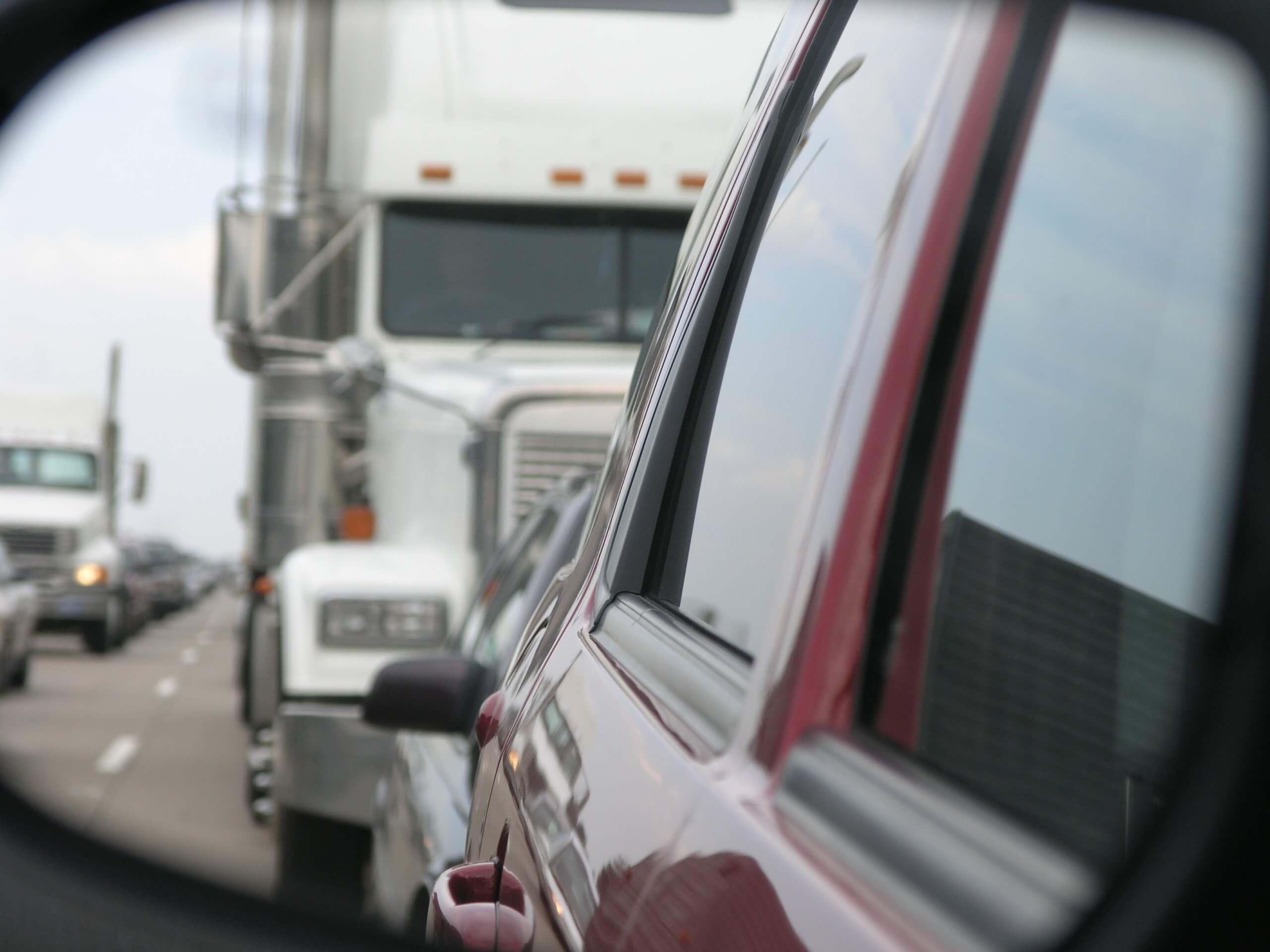 View of a truck in a car's rearview mirror.